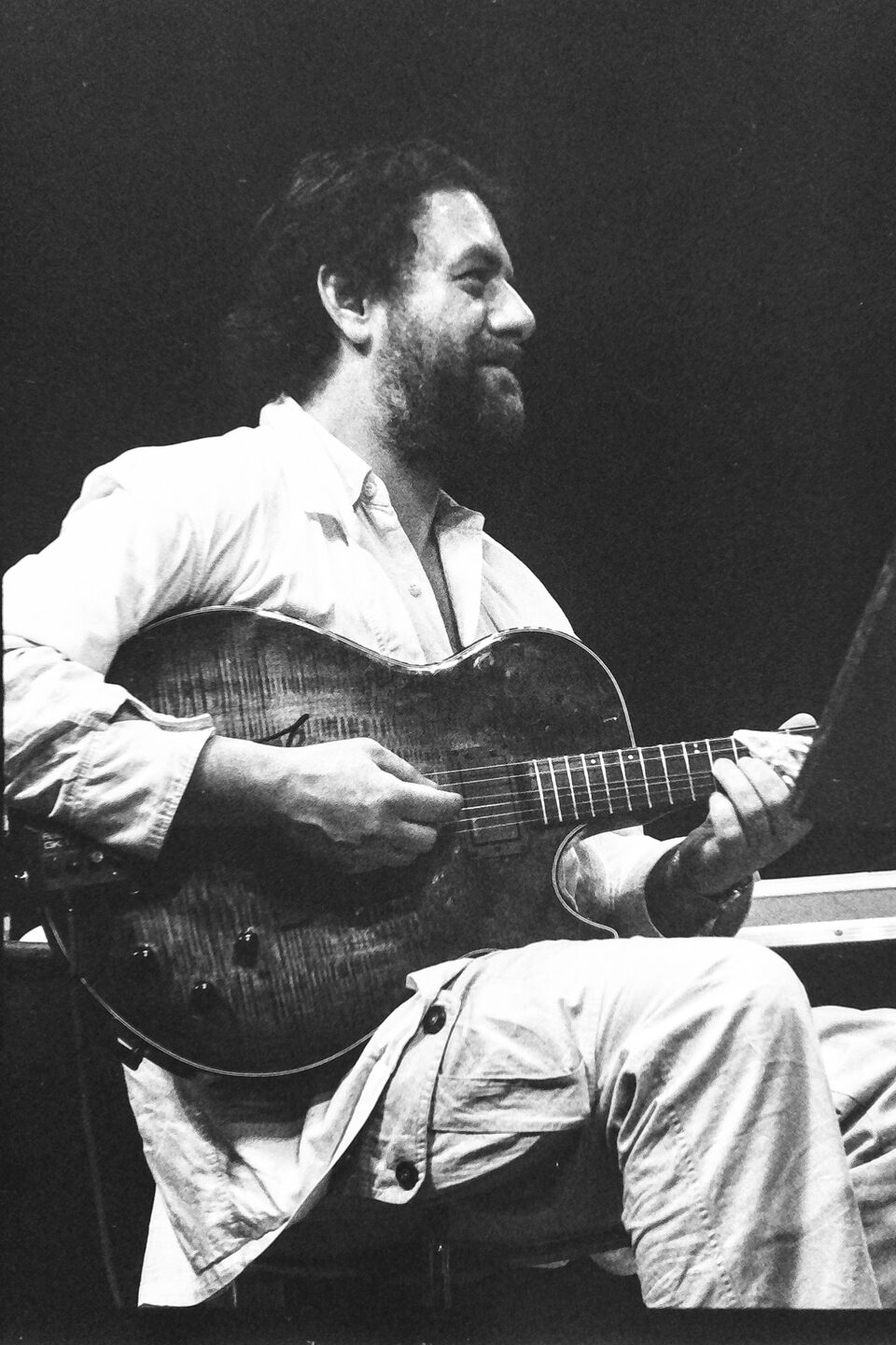 Harry Pepl lächelnd mit der Archtop-Gitarre auf der Bühne des Jazzfestivals Amiens, Frankreich, im Mai 1987.