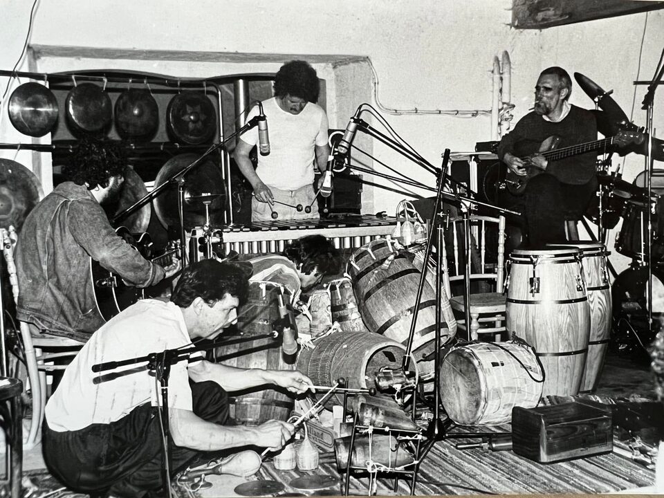 Schwarzweißfoto zwischen Gongs, Fässern und Trommeln: links Harry Pepl mit der Gitarre, in der Mitte Werner Pirchner am Vibrafon, rechts Steve Swallow an der Bassgitarre, vorne Perkussionisten der Family of Percussion. Vermutlich beim NDR-Jazzworkshop mit der Family of Percussion am 21. Juni 1984 in Hamburg; Namen nach Angaben der Familie.