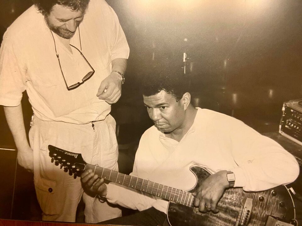 Sepiafoto aus der Zeit in Frankreich, 1986 oder 1987: Jack DeJohnette sitzt mit Harry Pepls Ibanez-Gitarre und hält sie wie ein Linkshänder, Harry Pepl steht daneben und schaut zu. Pepl und DeJohnette spielten damals mit Michel Portal. Links Harry Pepl, rechts Jack DeJohnette.