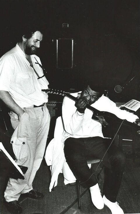 Schwarzweißfoto, laut Daniel Pepl in Paris, 1987: Jack DeJohnette sitzt mit Harry Pepls Ibanez-Gitarre und hält den Gitarrenhals an den Mund, als wolle er hineinbeißen, wie Jimi Hendrix, der die Gitarre bisweilen mit den Zähnen spielte. Harry Pepl, eine Hand in der Hosentasche, schaut lachend zu. Im Hintergrund ein Verstärker, ein Mikrofon und ein Notenpult mit Noten. Daniel Pepl nannte die Szene 2014 „jimi dejohnette“. Fotografiert hat Heimo Steps, Pepls Förderer und Manager in Graz. Links Harry Pepl, rechts Jack DeJohnette.