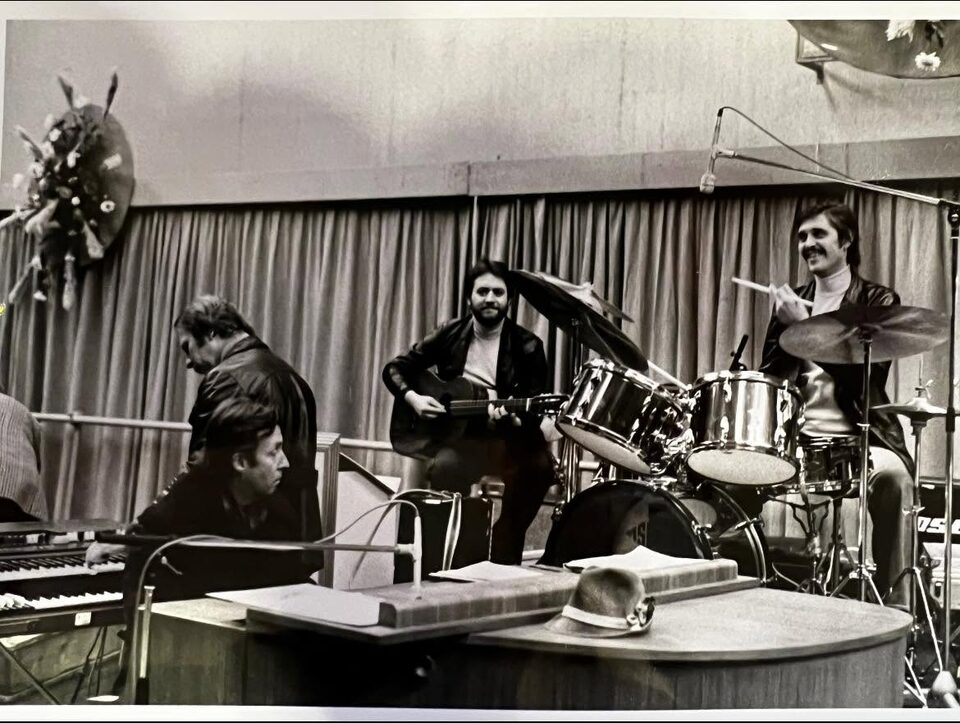 Schwarzweißfoto aus den 1970er Jahren: links an den Tasteninstrumenten Peter Alexander, in der Mitte Harry Pepl mit akustischer Gitarre, rechts lachend Fritz Ozmec am Schlagzeug. Nach Angaben der Familie eine Jam-Session vor einem Auftritt.