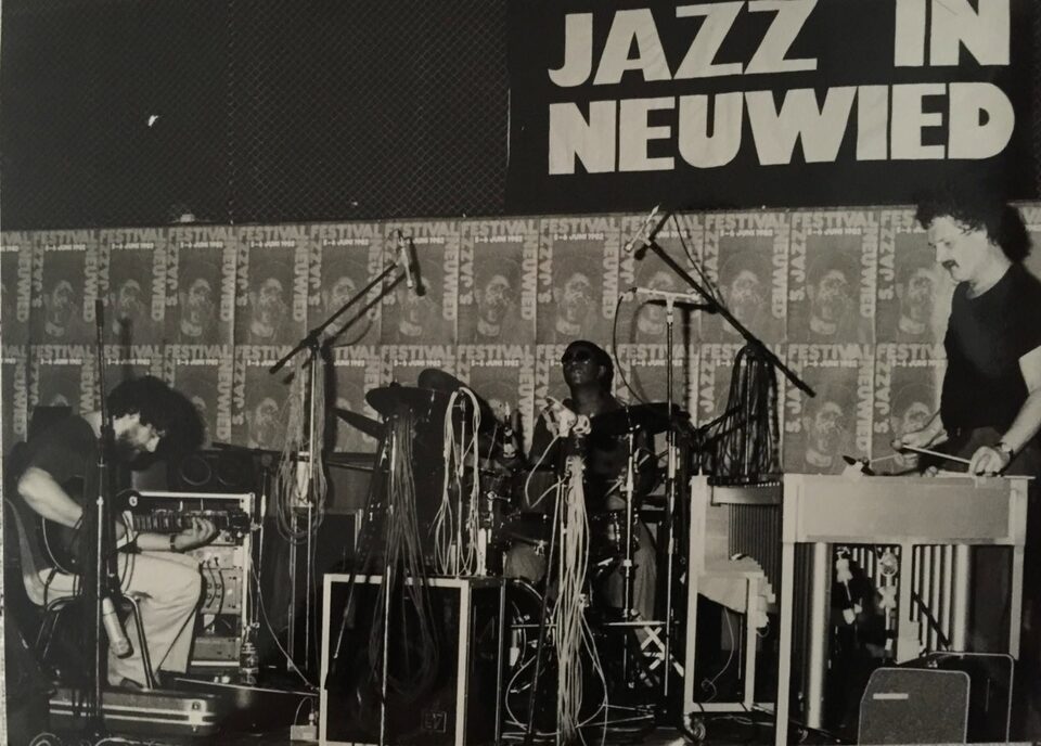 Auf der Bühne unter dem Banner „Jazz in Neuwied“: Harry Pepl an der Gitarre, Jack DeJohnette am Schlagzeug und Werner Pirchner am Vibrafon. Von links nach rechts: Harry Pepl, Jack DeJohnette und Werner Pirchner.