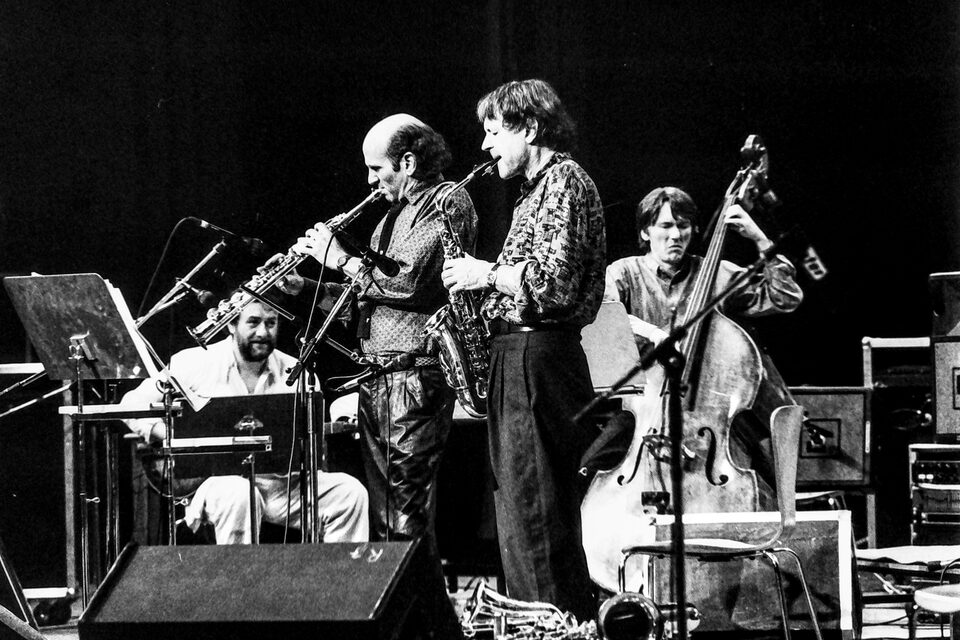 Jazzfestival Amiens, Frankreich, Mai 1987: Harry Pepl lächelnd mit der Gitarre, daneben zwei Bläser und der Kontrabass. Von links nach rechts: Harry Pepl, Dave Liebman mit dem Sopransaxophon, Michel Portal mit dem Altsaxophon und Jean-François Jenny-Clark am Kontrabass. Die Namen nannte der Fotograf Frank Lantiez; sie stimmen mit der Besetzung von „Men's Land“ überein, dem Livealbum vom selben Festival.