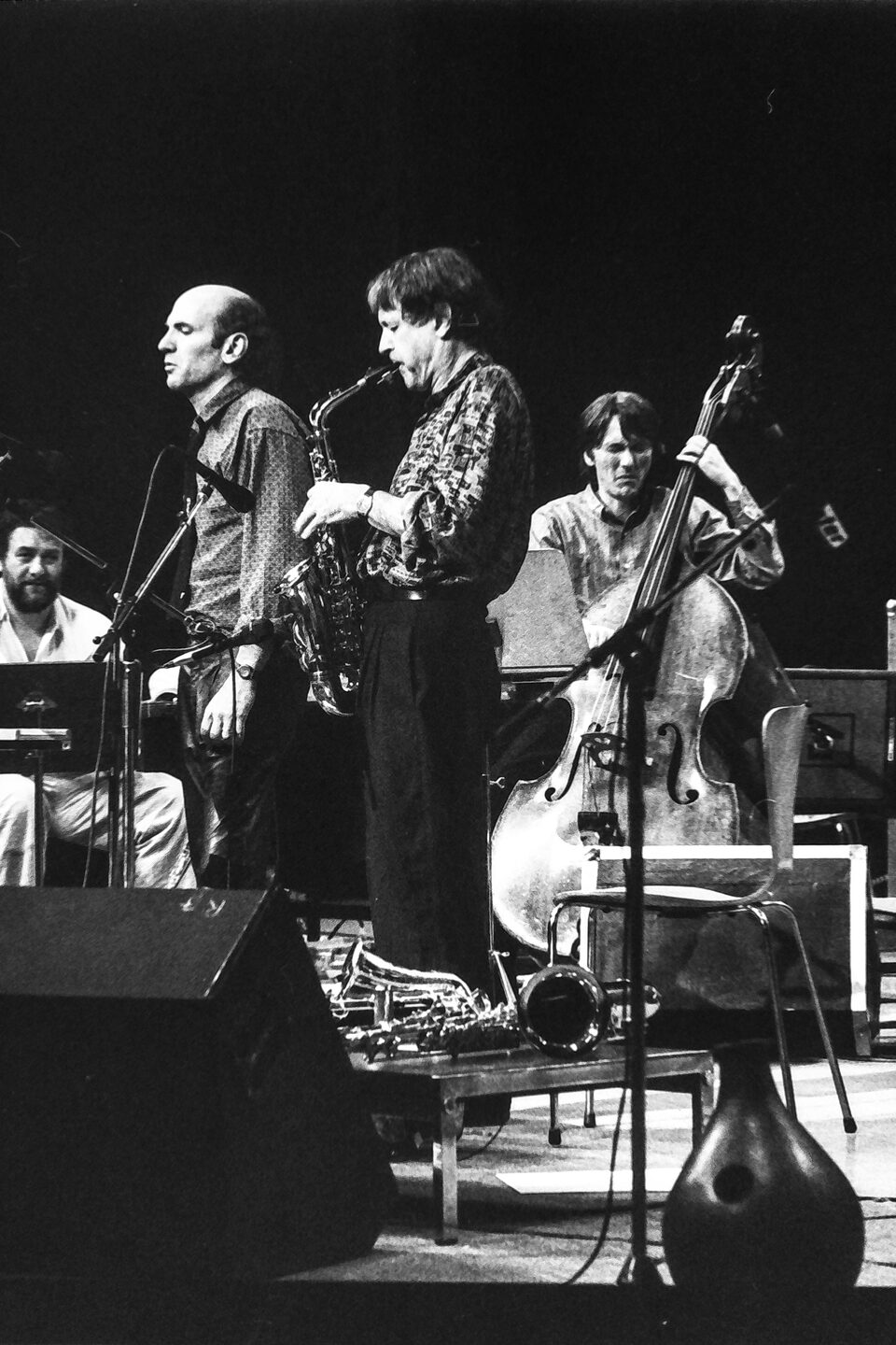 Bühne beim Jazzfestival Amiens, Frankreich, Mai 1987: vorn zwei Saxophonisten und der Kontrabass, links sitzend Harry Pepl mit der Gitarre. Von links nach rechts: Harry Pepl, Dave Liebman, Michel Portal mit dem Altsaxophon und Jean-François Jenny-Clark am Kontrabass. Die Namen nannte der Fotograf Frank Lantiez; sie stimmen mit der Besetzung von „Men's Land“ überein, dem Livealbum vom selben Festival.
