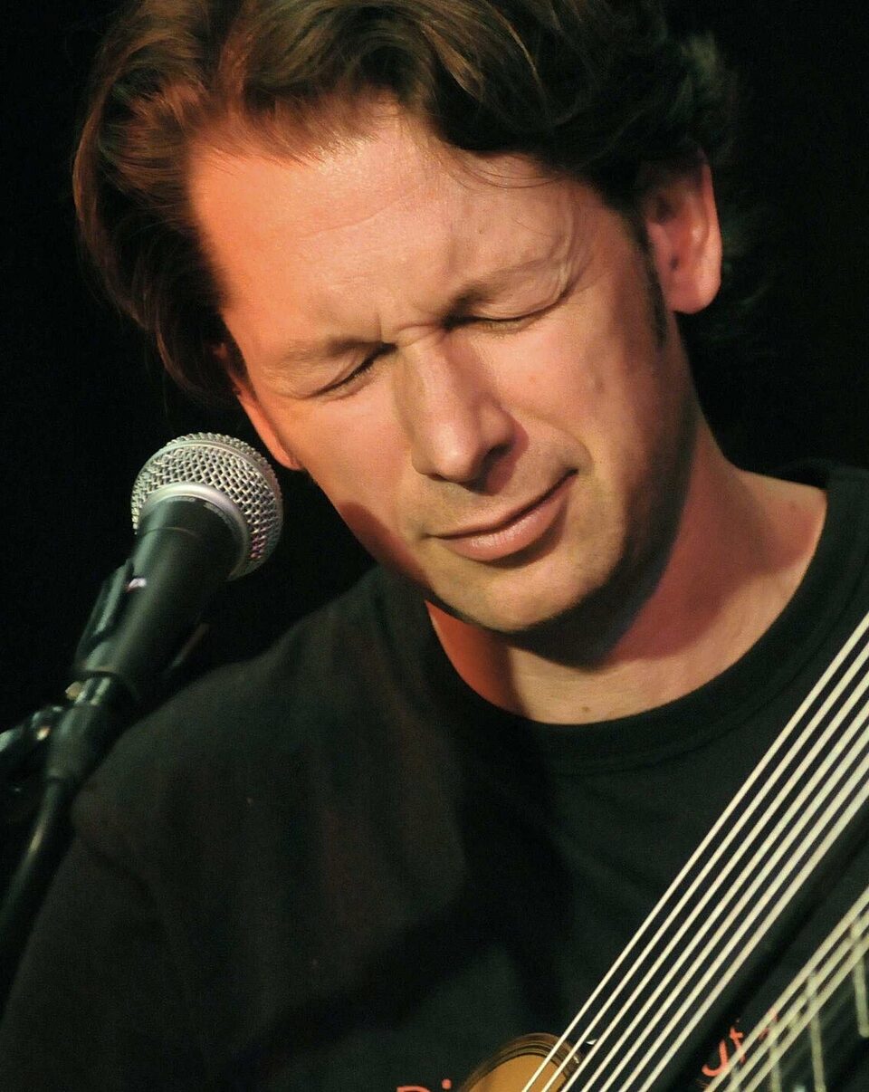 Peter Havlicek with a guitar at a concert, 2014.