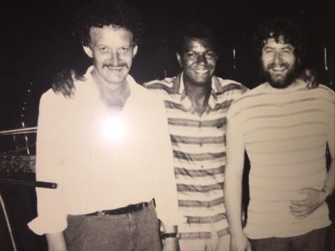 Schwarzweißfoto: Werner Pirchner, Jack DeJohnette und Harry Pepl Arm in Arm, alle drei lächeln in die Kamera. Von links nach rechts: Werner Pirchner, Jack DeJohnette und Harry Pepl.